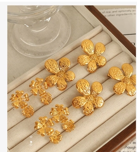 Detailed collection of 18K gold plated stainless steel flower earrings in a jewelry box