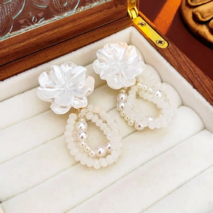 Close-up of pearl flower earrings in a jewelry box showing fine textures and details