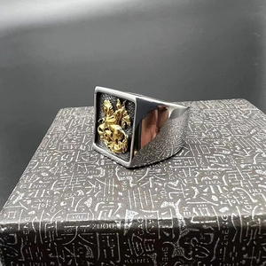 Détail d'une chevalière en argent avec un relief de chevalier doré sur la surface de l'anneau