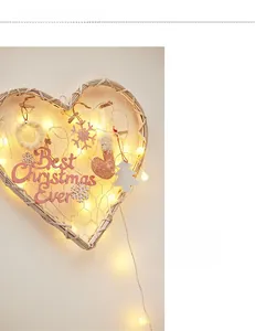 Detail of heart-shaped rattan Christmas wall hanging with warm LED lights and ornaments