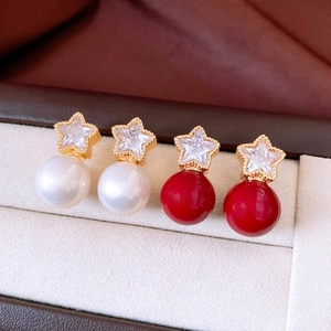 Detailed shot of star-shaped earrings with red and white pearls in a jewelry box