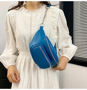 Blue PU leather waist bag featuring chain strap and double zipper pockets on a model