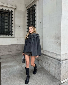 Close-up of a dark grey knit wool blend scarf on a model with an oversized style