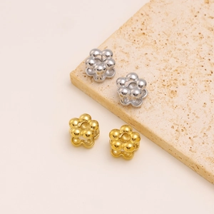 Detail of four flower-shaped earring backs in gold and silver finish on stone