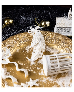 Exquisite white pearl star and house Christmas tree ornaments on a golden plate with snow