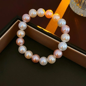 Macro detail of multi-color pearls in white and pink tones on a black jewelry box