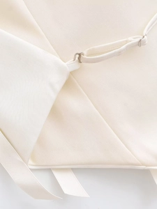 Detailed view of ivory satin top featuring adjustable metal buckles and cross-tie lacing
