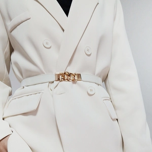 Detail of a thin white leather belt with a golden chain buckle on a blazer
