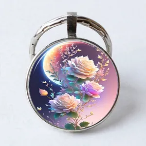 Close-up of circular glass cabochon keychain featuring a rose and moon art illustration