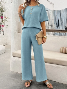 Detail of light blue two-piece knit set featuring short sleeve button top and wide leg pants