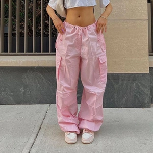 Gros plan du pantalon cargo parachute rose avec coupe ample et détail de cordon