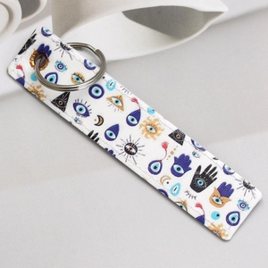 Detailed view of faux leather keychain with evil eye and hand of fatima prints
