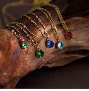 Artistic close-up of gold stainless steel necklaces with colorful birthstone pendants
