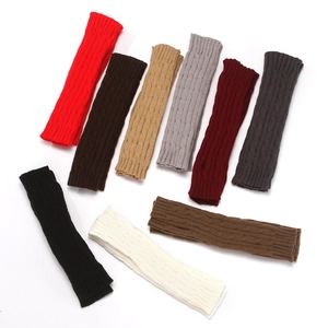 Detailed view of knitted leg warmers in various colors with cable knit patterns