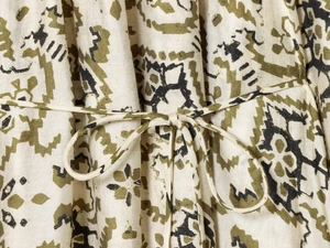 Gros plan sur une robe à imprimé olive avec détail de la ceinture nouée et texture du tissu