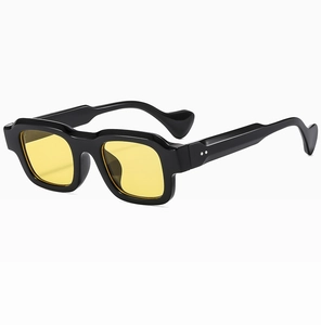 Detail of trendy small frame sunglasses featuring yellow lenses and silver double rivets