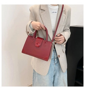 Dettaglio della borsa tote rosso scuro con trama coccodrillo e tracolla regolabile
