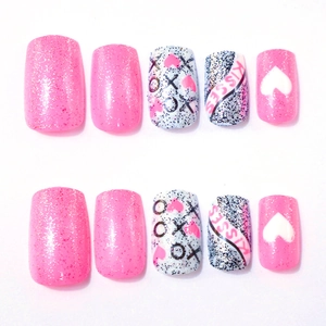 Detail of short square press-on nails featuring pink glitter and XOXO heart designs