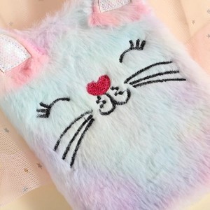 Close-up of rainbow plush cat diary with embroidered face and glittery heart details