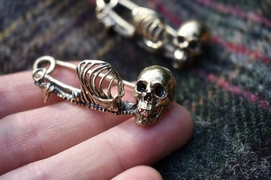Retro punk skull safety pin brooch in vintage bronze finish on dark wool fabric