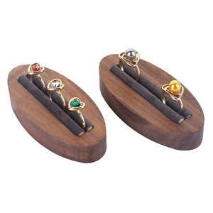 Minimalist walnut wood ring display stand with grey velvet slots and gold jewelry