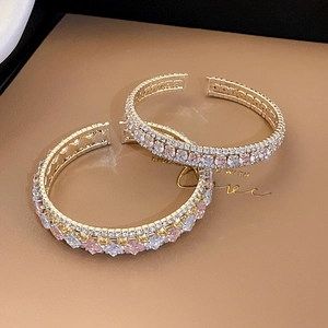 Détail macro du bracelet jonc plaqué or avec des pierres de zircone carrées roses et blanches