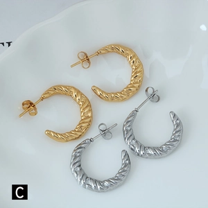 Detailed close-up of twisted rope texture C-shape earrings in gold and silver finishes