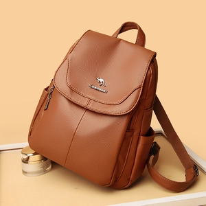 Brown leather backpack for women with flap design and metal logo in studio lighting