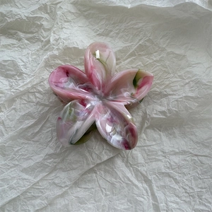 Detail of marble pattern flower hair claw clip with pink and green acetate textures