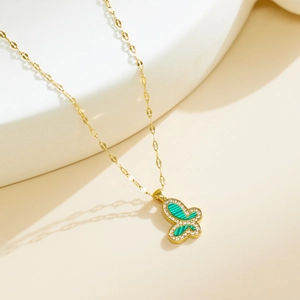 Detail of golden butterfly pendant with malachite texture inlay and small crystals