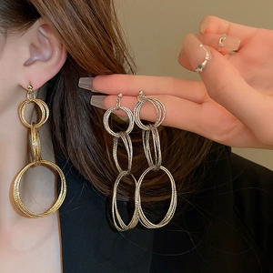 Golden multi-layered nested circle drop earrings with fine texture on model
