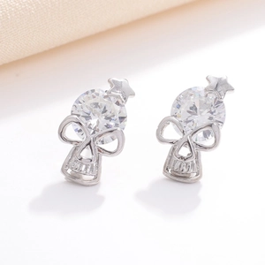 Macro shot of silver skull earrings with round cubic zirconia and star detail