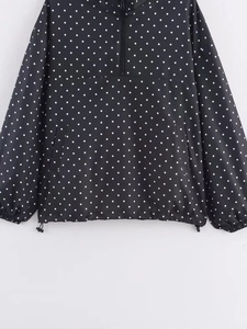Détail du coupe-vent femme à pois noirs avec demi-fermeture éclair et cordon de serrage