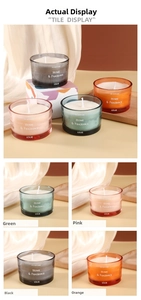 Dettaglio macro di quattro candele profumate in vetro nei colori verde rosa nero arancio