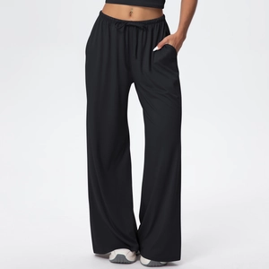 Detail view of high-drape fabric texture and drawstring elastic waist on black wide-leg pants