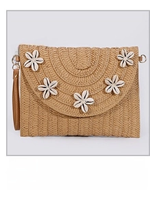 Detail of straw woven clutch bag featuring white shell flower patterns and tassel accents