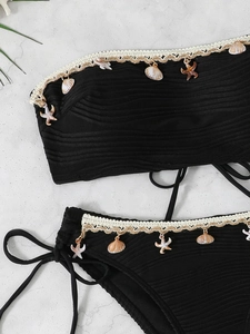 Detailed view of black ribbed bikini with crochet lace shell and starfish pendants