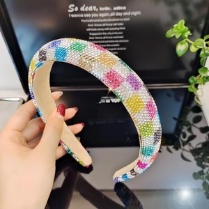 Close-up of wide headband with colorful rhinestones in blue, green, and pink patterns