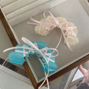 Beige and blue acetate hair claws with pink ribbon bow detail in a soft jewelry box