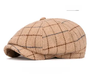 Detail of beige plaid newsboy hat featuring premium wool texture and button top