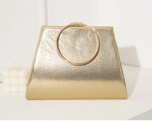 Detail of gold trapezoid evening clutch with metallic ring handle and glitter fabric