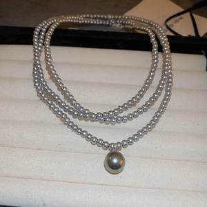 Elegant gray pearl necklace featuring a matching large round pearl pendant on a tray