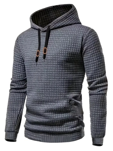 Detail of grey men's hoodie featuring square grid texture fabric and hooded drawstring