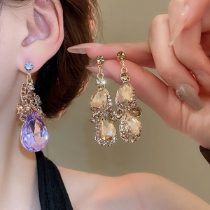Detailed comparison of purple and champagne teardrop crystal earrings on model