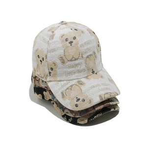Stack of trendy baseball caps with cute cartoon bear pattern and Happy Little Bear text