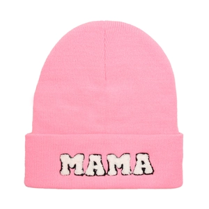 Detail of pink knitted beanie with MAMA embroidered plush patch and clear stitch texture