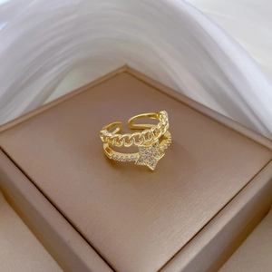 Detail of double-layer gold star ring with micro-pave crystals on brown jewelry box