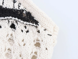 Detailed close-up of the black and cream crochet knit pattern on a slim-fit dress