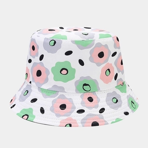 Detail of floral print on a white cotton sun hat featuring pink and green blossoms