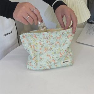Detail of floral canvas makeup bag showing interior storage capacity and small flower print
